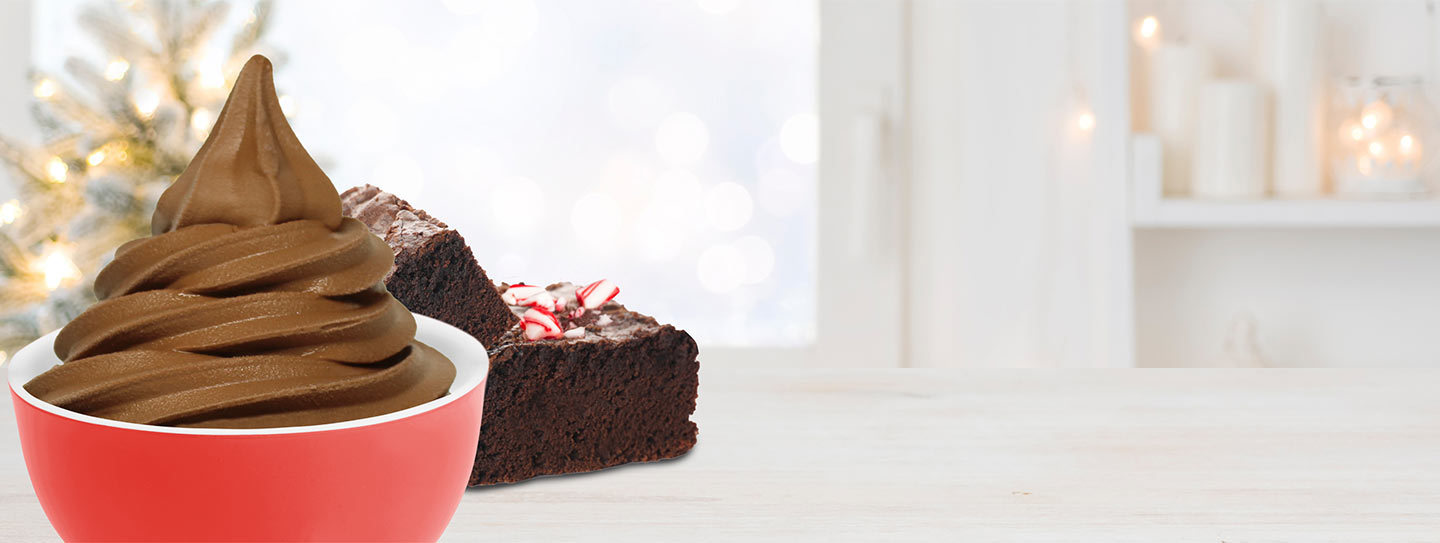 A cup of frozen yogurt alongside peppermint brownies.