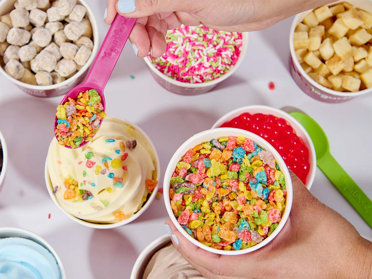 An assortment of Yogurtland frozen yogurt cups and toppings
